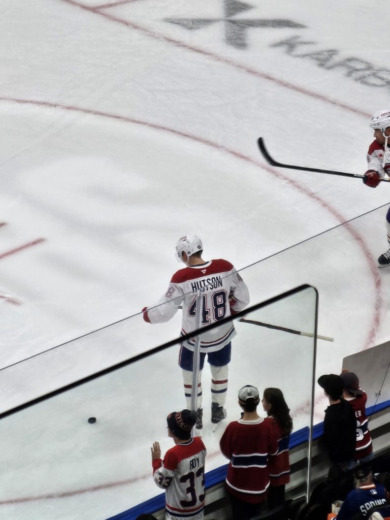 Lane Hutson wearing number 48 on the ice, photographed from the stands.